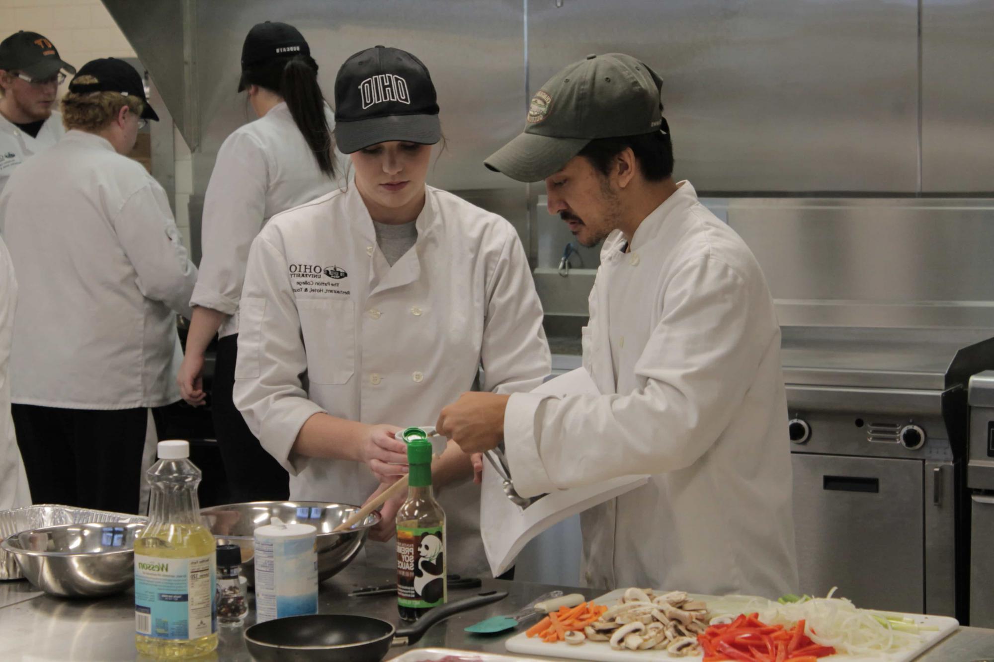 Culinary students work together while cooking.