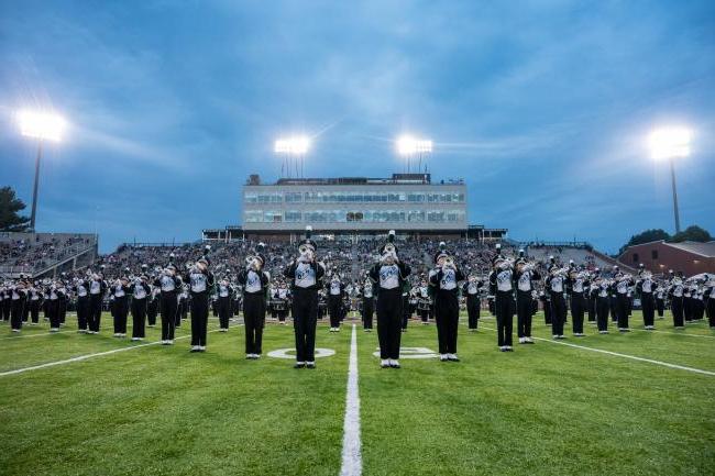 Members of the Ohio University Marching Band play on field during a football game