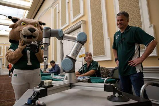 Ohio University's mascot looks at a robot